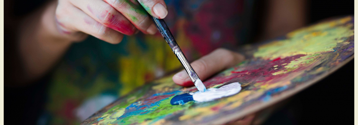 Paint brush mixing colors on a pallet by a local Montana artist