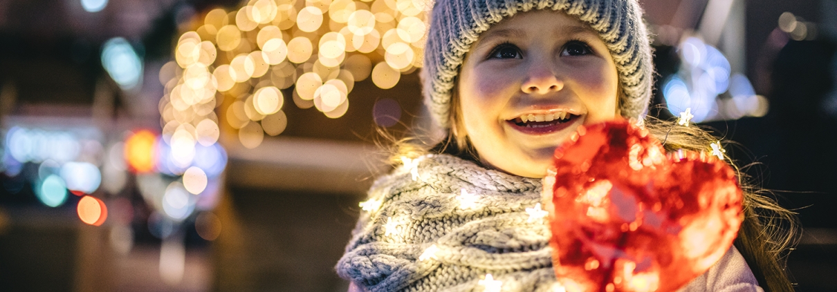 A little girl in winter holding red lights at the Annual Christmas Convoy Belgrade, MT.